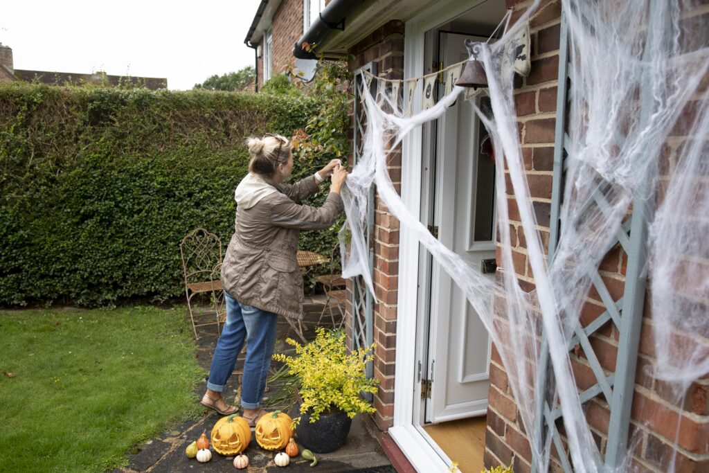 woman decorating her home halloween scaled